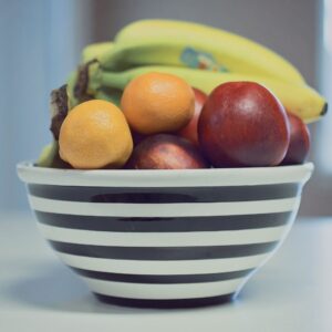 A vibrant assortment of fresh fruits in a striped bowl, ideal for healthy living.